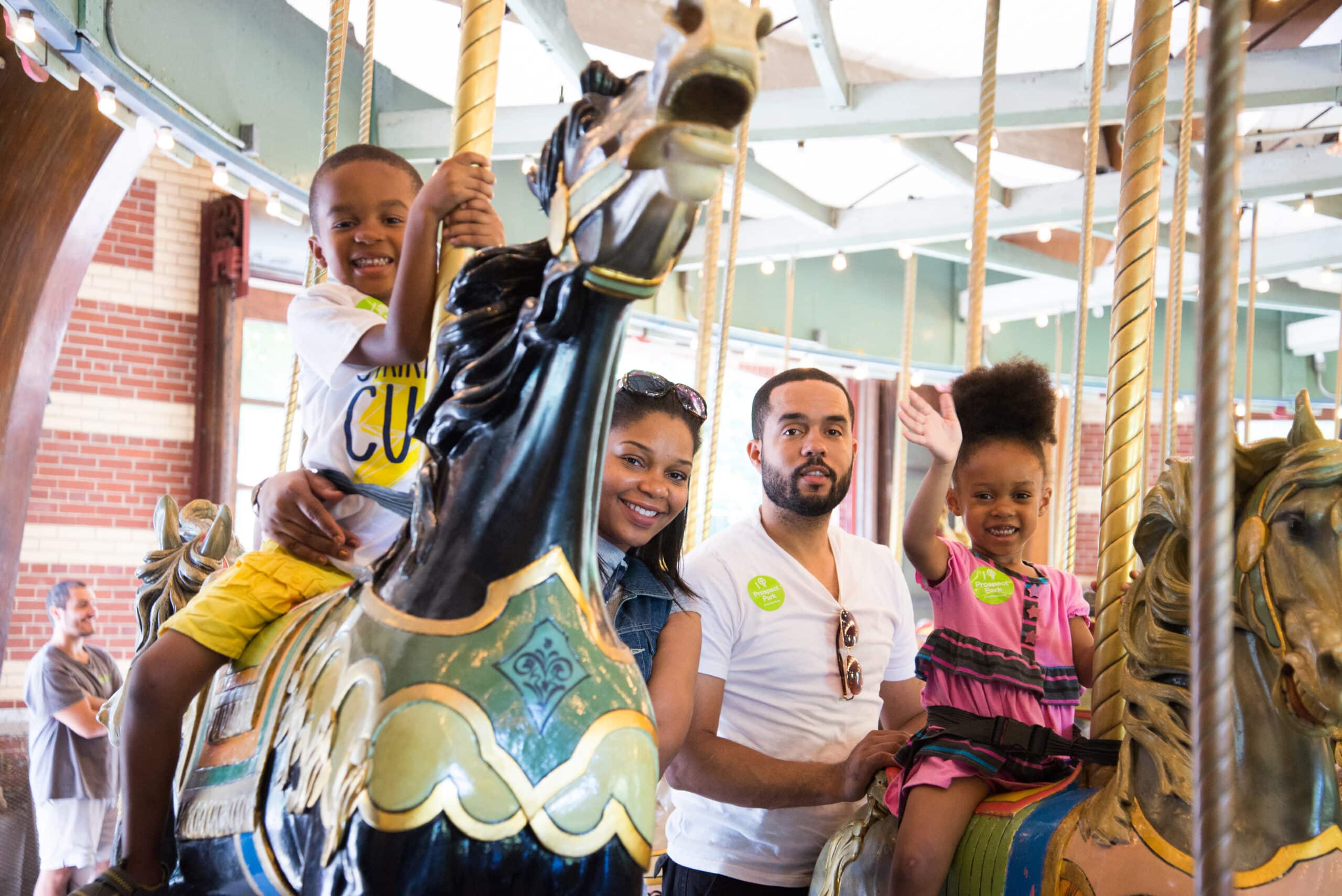 Family poses for picture at Carousel during National Ice Cream Day at Prospect Park.